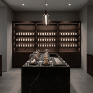 Intérieur d'une boutique de parfums de niche avec flacons minimalistes et matières premières exposées sur un comptoir en marbre.