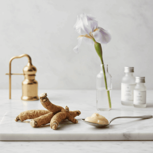Dried iris rhizomes and iris butter on marble, illustrating the most expensive raw material in perfumery.