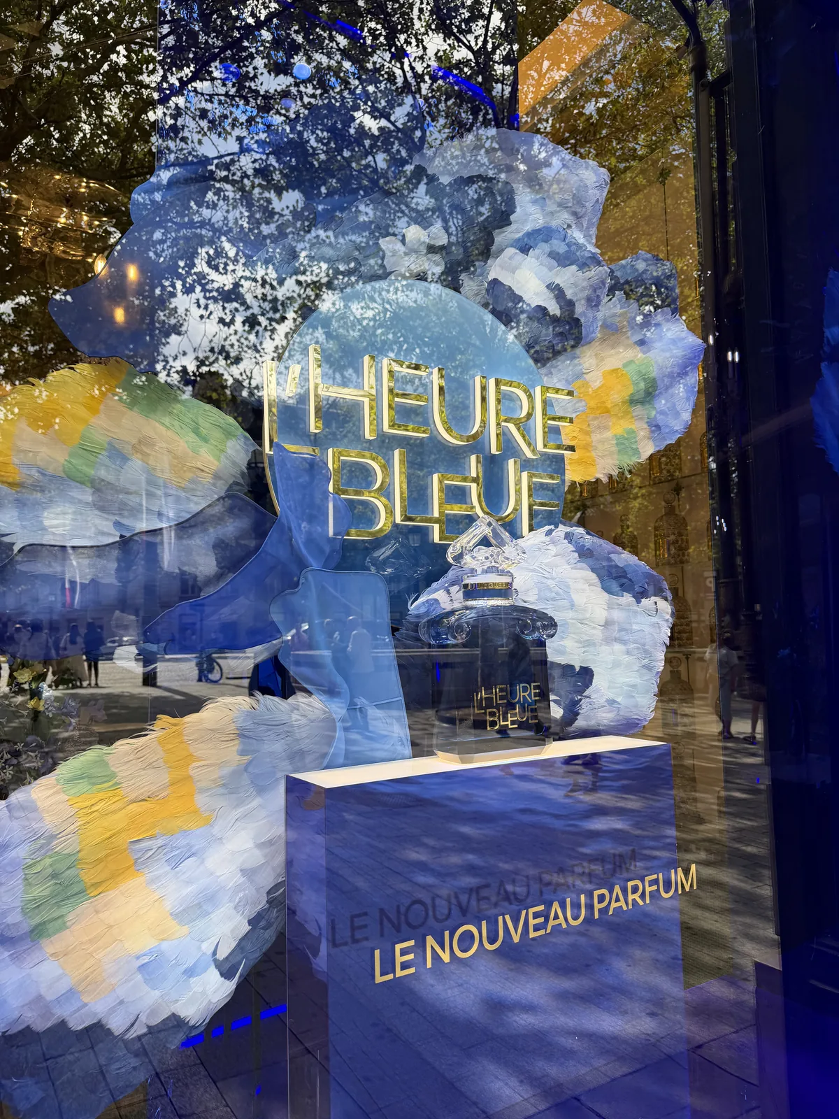 Logo doré L'Heure Bleue et mention « Le nouveau parfum » dans la vitrine Guerlain.