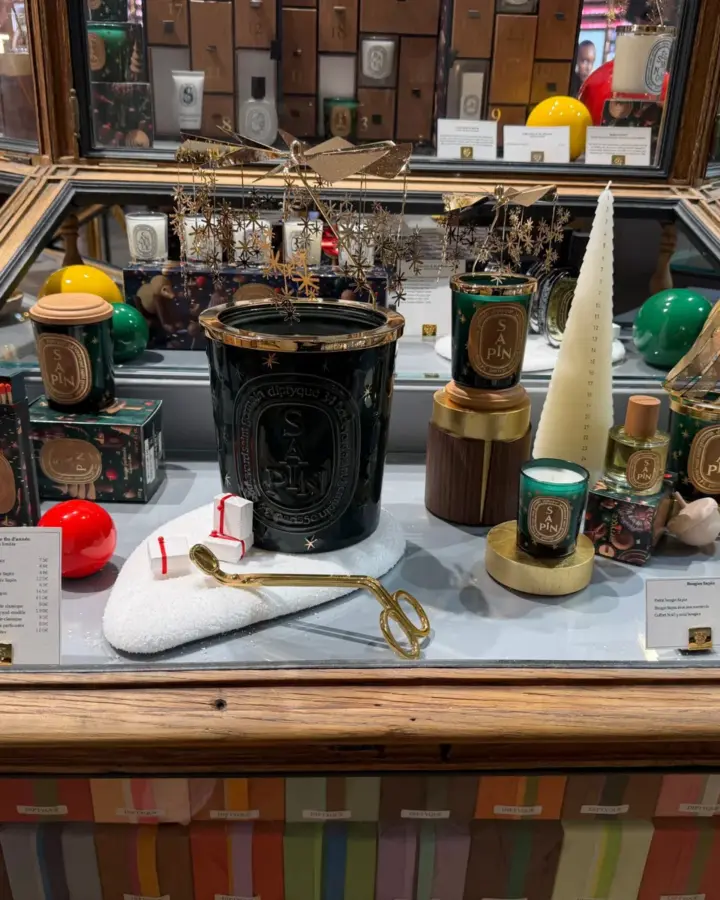 Vitrine de Noël Diptyque avec les bougies Sapin, des boules de Noël et un calendrier de l'Avent.