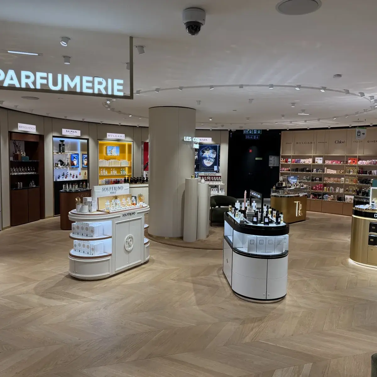 L'espace parfumerie d'un grand magasin, ses vitrines et ses comptoirs de marques.