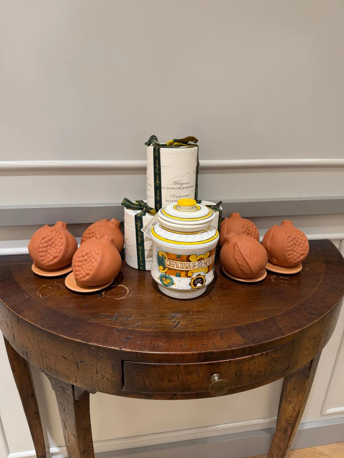 Grenades parfumées en terre cuite Melograno de Santa Maria Novella sur une console en bois.